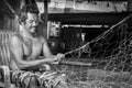 Thai fishermen mending his fishing net in Thailand