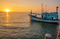 A fishing boat at a pier in the early evening during sunset time Royalty Free Stock Photo