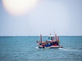 Thai fishing boat traditional used as a vehicle for finding fish in the sea at sunset.