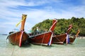 Thai fishing boats tied up on the beach with a beautiful island in the background, Krabi, Thailand Royalty Free Stock Photo