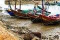 A Thai-flagged fishing boat is stranded on the pier.