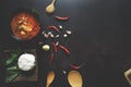 Thai food background concept. Dish of Thailand cuisine. Tom yum soup in black dish, rice in wooden plate, wooden ladle and spoon, Royalty Free Stock Photo