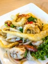 Thai Food Cuisine: Yum Sam Krob, Crispy Fish Maw, deep fried Squid and Shrimp in Spicy Mixed Cashew Nut Salad in white plate Royalty Free Stock Photo