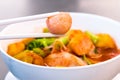 Thai food.Hold chopsticks to meat ball.Pink seafood flat noodles.Spicy lemongrass flavored soup with pork, chicken Royalty Free Stock Photo