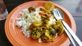 Thai food with spicy chicken yellow curry, brinjal and stewed Egg on white rice with fork and spoon on orange dish or plate Royalty Free Stock Photo