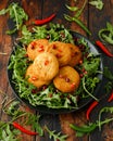 Thai food spicy fish cakes served with pomegranate seeds and wild rocket, arugula salad. Royalty Free Stock Photo
