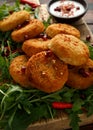 Thai food spicy fish cakes served with pomegranate seeds and wild rocket, arugula salad. Royalty Free Stock Photo