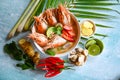Thai Food Tom Yum Kung, Hot and sour spicy shrimps prawns soup curry lemon lime galangal red chili straw mushroom on table food, Royalty Free Stock Photo