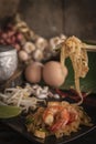 Thai fried noodles or pad thai with shrimp on black plate placed on the wood table there are eggs, garlic, bean sprouts, shallot, Royalty Free Stock Photo