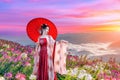 Thai girl in a Chinese dress stands in the middle of a field of flowers in the morning