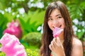 Thai girl is eating pink candyfloss with joy