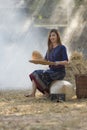 Thai girl winnowing rice separate between rice and rice husk on farm background