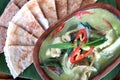 Thai green curry chicken with roti in wood bowl, closeup food Royalty Free Stock Photo