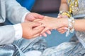 Thai groom`s hand putting a wedding ring on the bride`s finger. Royalty Free Stock Photo