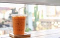 Thai iced ice tea is placed on a wooden tray on a table, copy space for letters