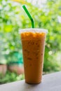 Thai iced milk tea in a plastic cup on the wood table Royalty Free Stock Photo