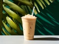 Thai iced tea in a plastic cup with a straw and palm leaf on a green background. AI Generative Royalty Free Stock Photo