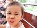 Thai little girl with beautiful bright eyes making funny face, feeling angry Royalty Free Stock Photo