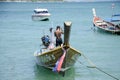 Thai man inspect and repair wooden fishery boat floating