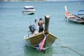 Thai man inspect and repair wooden fishery boat floating