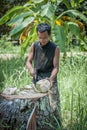 Thai man peels fresh coconut in the jungle