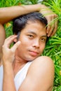 Thai man in white tank top pose sissy in the garden Royalty Free Stock Photo