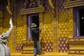 Thai man worker people and profesional builder working renovate build church and spray painting gold color ubosot or ordination