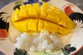 Thai mango and sweets sticky rice with coconut milk serve on vintage retro dish for travelers people eating at restaurant cafe