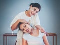 Thai Massage Therapist Masseur giving an Asian woman a neck stretching