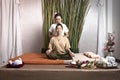 Thai Masseuse doing massage for woman in spa salon. Asian beautiful woman getting thai herbal massage compress massage in spa.She Royalty Free Stock Photo