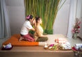 Thai Masseuse doing massage for woman in spa salon. Asian beautiful woman getting thai herbal massage compress massage in spa.She Royalty Free Stock Photo