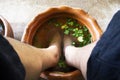 Thai men people sit relax and foot bath in basin with herb herbal before local spa massages thai style Koh Kret island in Pak Kret