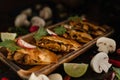 Thai and mexican fusion food background of spicy chicken and mushroom tomyum quesadillas on wooden plate in dark tone, selective