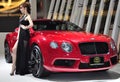 Thai model stands next to a Bentley convertible