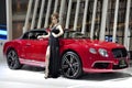 Thai model stands next to a Bentley convertible