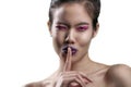 Thai model wears purple lipstick very close shot of mouth and teeth. shot on a white backdrop.