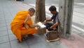 Thai Monk look at the religious amulets of a street vendor