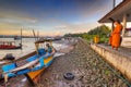 Thai monk meditating at sunrise on the harbor