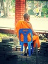 Thai monk sitting on a chair.