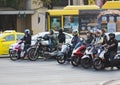 Thai motorcyclists stand at traffic lights