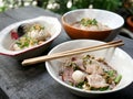 thai noddle of jumbo pork ball, pig liver, pork slide and vegetable on wooden table, hot noodle with blood pink for soup, in Thai Royalty Free Stock Photo