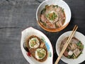 thai noddle of jumbo pork ball, pig liver, pork slide and vegetable on wooden table, hot noodle with blood pink for soup, in Thai Royalty Free Stock Photo