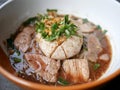 thai noddle of jumbo pork ball, pig liver, pork slide and vegetable on wooden table, hot noodle with blood pink for soup, in Thai