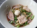 thai noddle of jumbo pork ball, pig liver, pork slide and vegetable on wooden table, hot noodle with blood pink for soup, in Thai Royalty Free Stock Photo