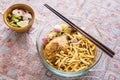 Thai northern curry noodle with chicken in glass bowl