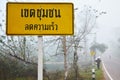 Thai people carrying sack walking at beside road with traffic sign