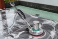 Thai people cleaning black granite floor with machine and chemical