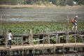 Thai people and foreigner travelers travel and walking visit on Kae Dam long wood bridge at Maha Sarakham, Thailand