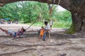 Thai people having a rest under shadow of old tree near Kata beach on Phuket, Thailand