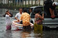Thai people natural disaster victims stand and wading in water on street of alley while water flood road wait help rescue and